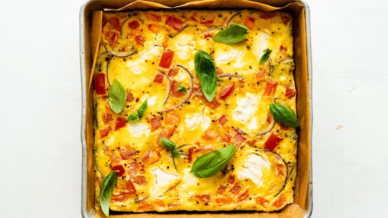 Egg and vegetable casserole in square baking pan.