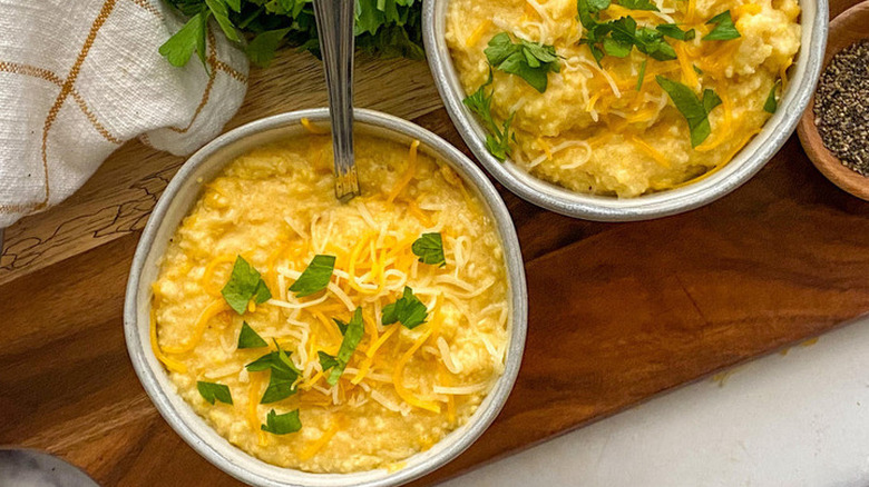 Bowls of grits topped with cheese and herbs.