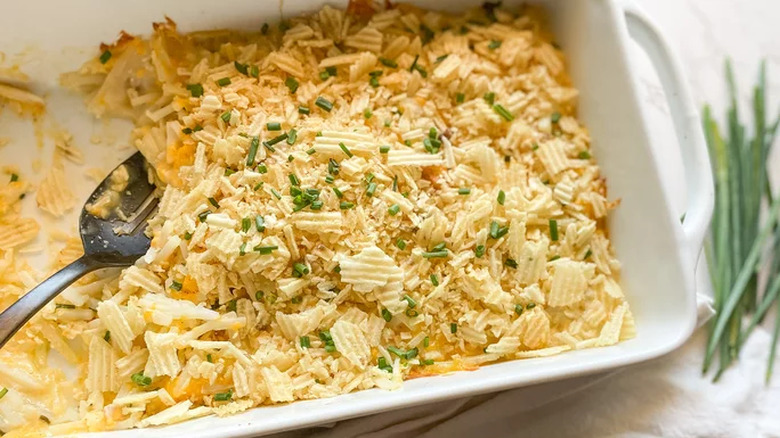 Baking dish with crushed potato chips over cheese filling.