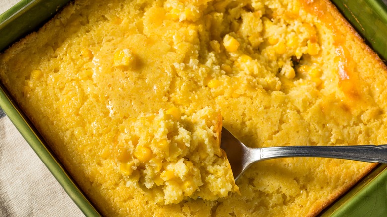 Baked cornbread casserole with spoonful scooped out.