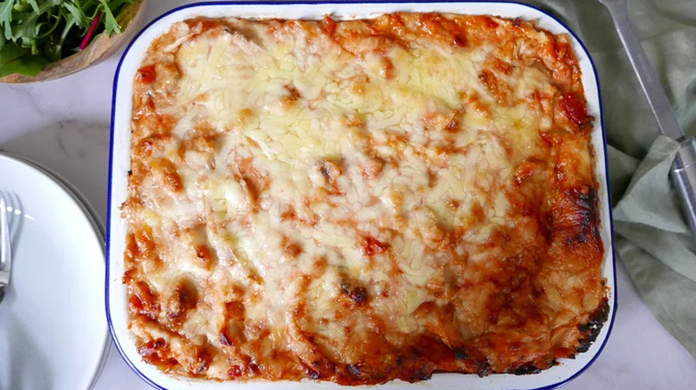 White pan with melted cheese-topped casserole.