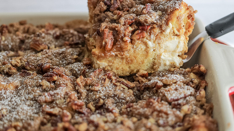 French toast casserole with streusel and slice lifted out.