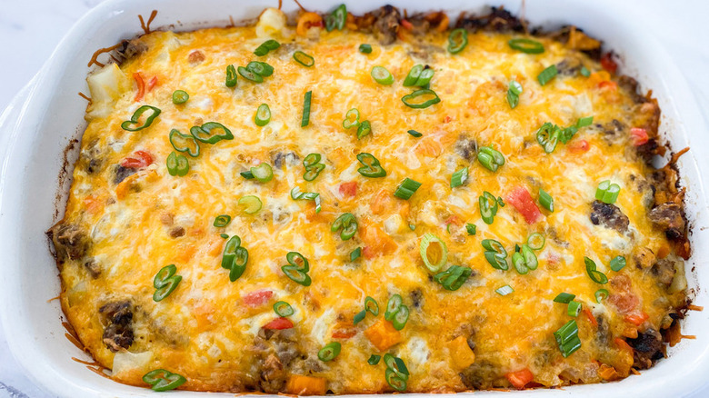 Baked sausage and hash brown casserole with melted cheese.