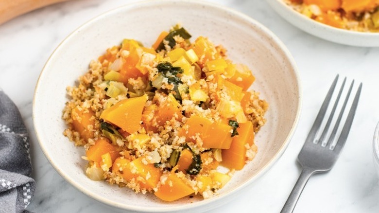 Serving of squash and leek casserole in a white bowl.