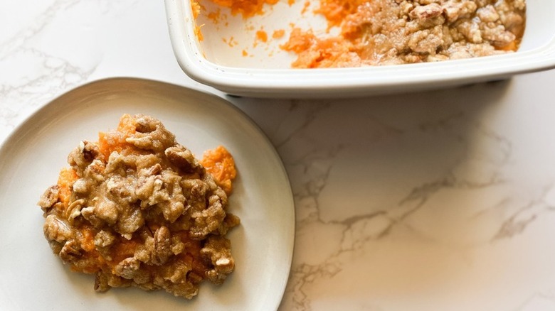 Mashed sweet potato topped with pecans and sugar.