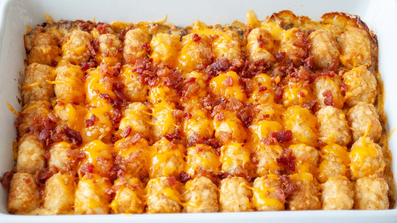 Rows of baked tater tots and cheese in a baking dish.