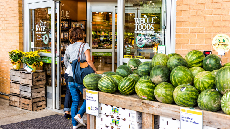 Customers entering a Whole Foods Market with watermelon display