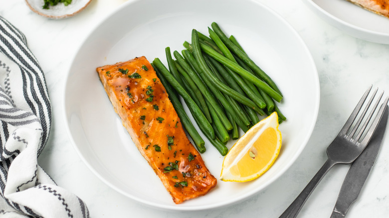 salmon with green beans and lemon wedge