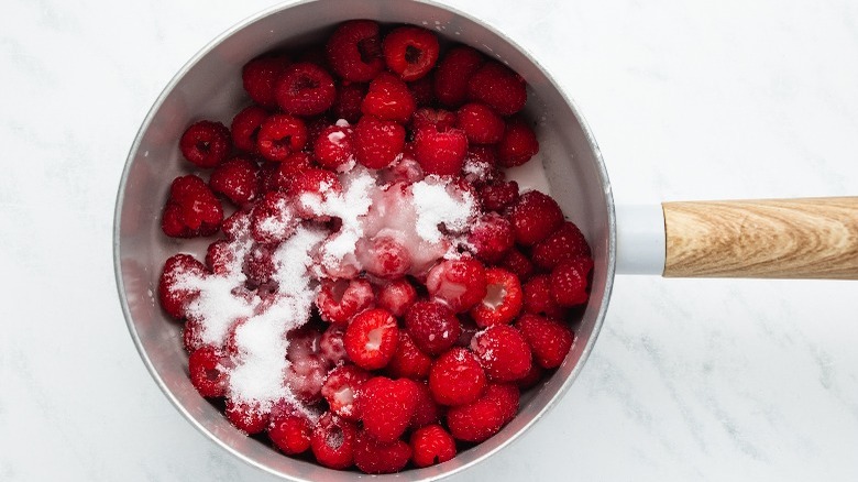 raspberries and sugar in a saucepan