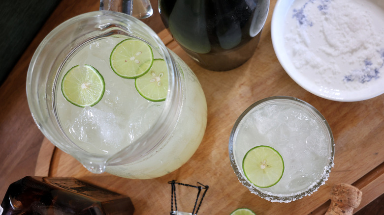 overhead shot of champagne margarita in rocks glass and pitcher of the same