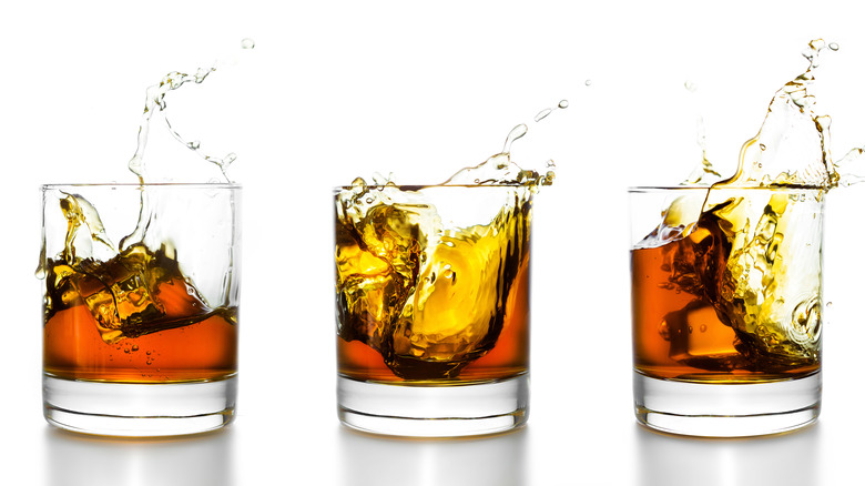 Three lowball glasses containing whiskey