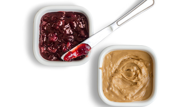 peanut butter and jelly in dishes against white background