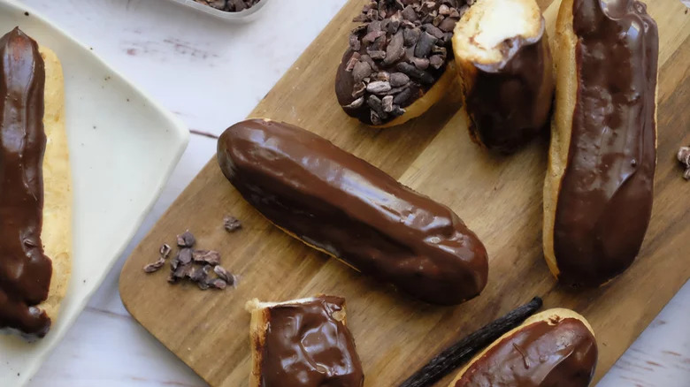 eclairs with chocolate glaze on wooden board