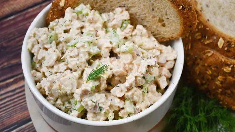 close up bowl of turkey salad with bread slices