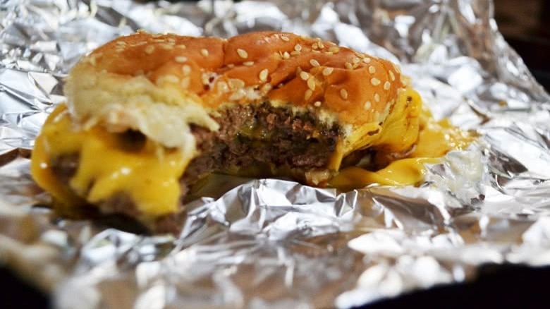 close up of five guys burger on aluminum foil