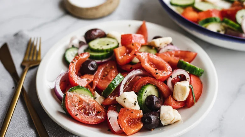 plate of Greek-Ish Salad With Marinated Cheese Curds with knife and fork