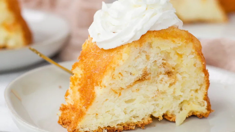 Slice of angel food cake with whipped cream on top.