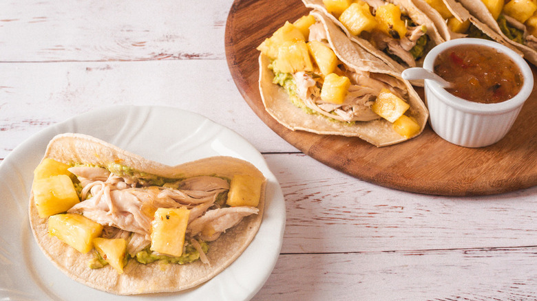 Soft taco shells with chicken and pineapple chunks.