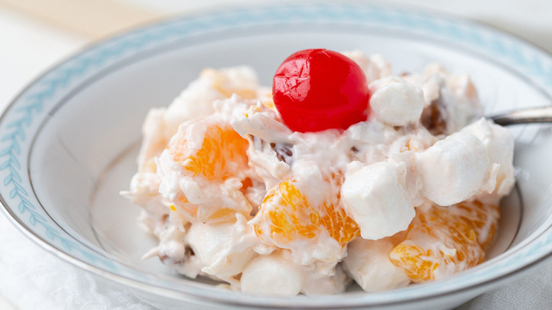 Orange, cherry, and marshmallow mixture in a bowl.