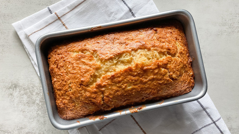 Baked loaf of banana bread in rectangular pan.