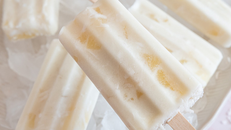 Creamy white popsicles with chunks of pineapple.