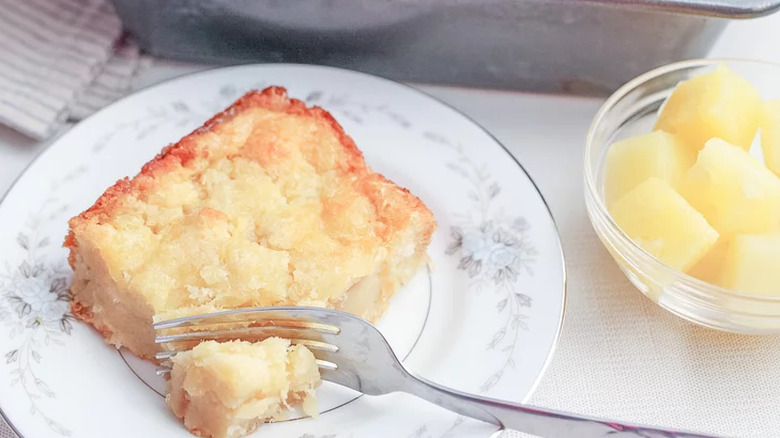 Slice of pineapple bake on plate with a fork.