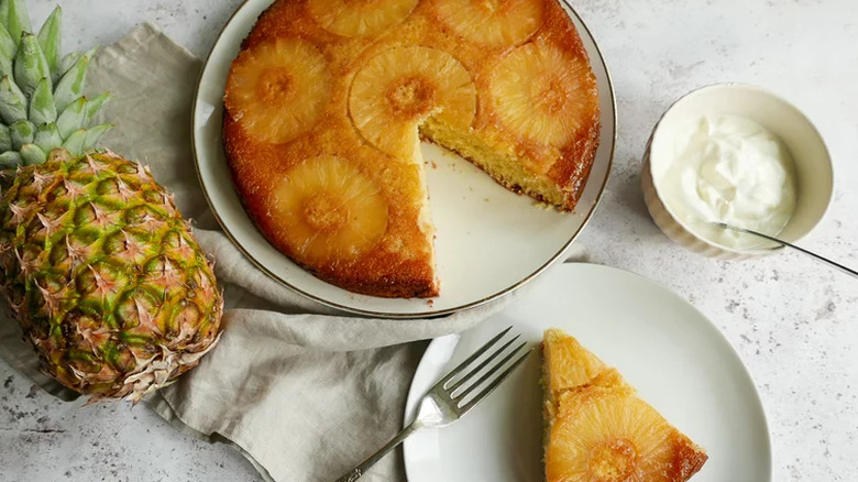 Whole pineapple ring-topped cake with slice cut out. 