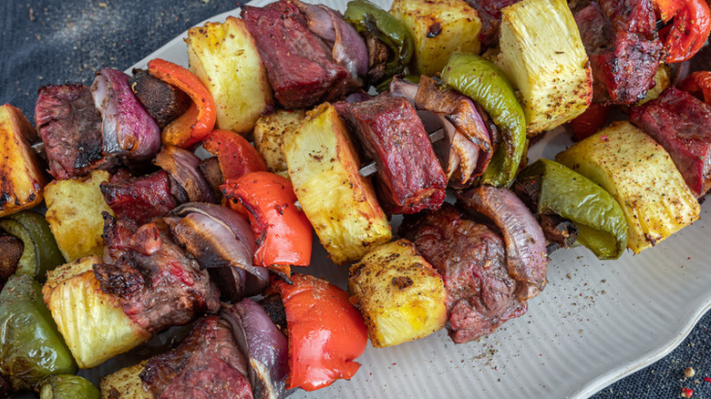Skewers with steak, peppers, onions, and pineapple. 