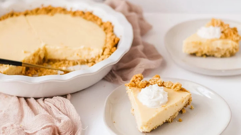 Lemon cream pie in pan and slices on plates. 