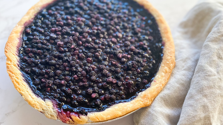 Round baked pie filled with wild blueberries