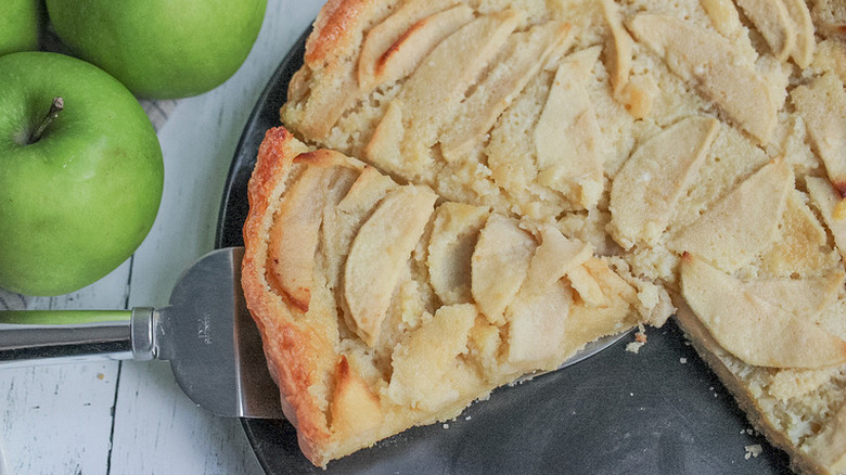 Individual tart with caramelized apple slices on a plate. 