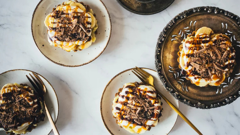 Small banana cream tarts topped with shaved chocolate.