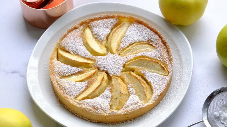 Round tart with spiral of sliced apples and powdered sugar.