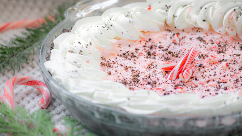 Pie dish with creamy peppermint filling and candy cane crumbles.