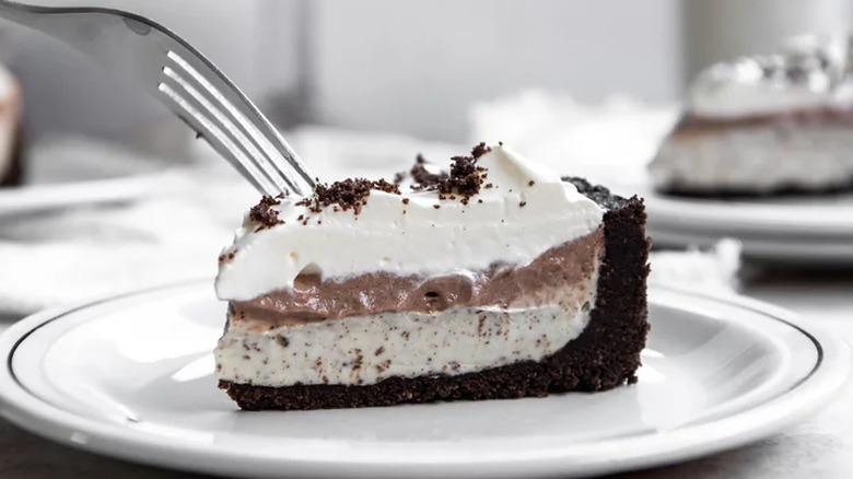 Slice of layered pudding pie with chocolate cookie crust.