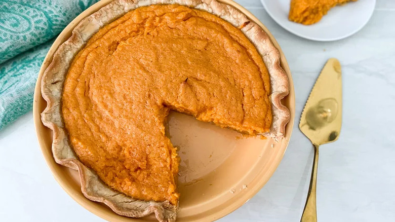 Round sweet potato pie with slice cut out. 