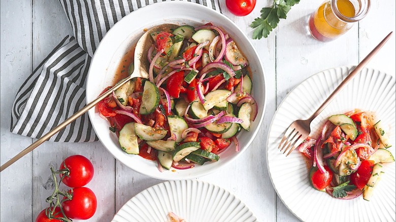 Cucumber tomato salad on white plates