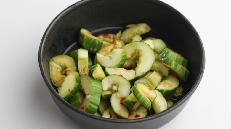 Smashed cucumber salad in black bowl