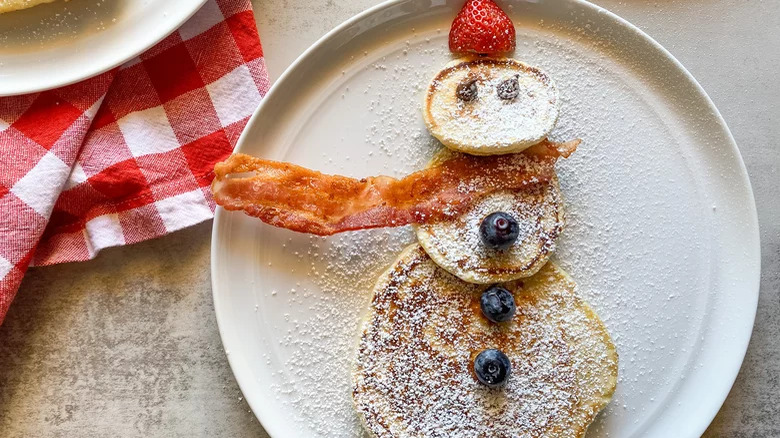 Pancakes snowman with berries and bacon