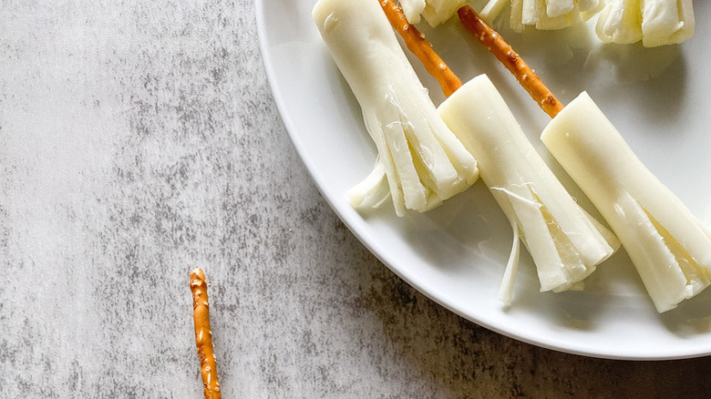 String cheese/pretzel broomsticks