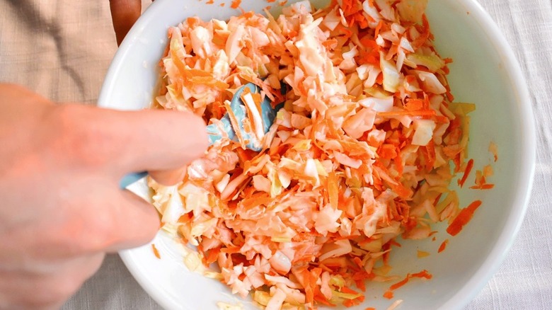 hand with bowl of coleslaw