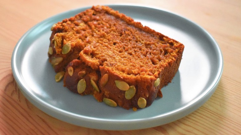 plate with slice of Copycat Starbucks Pumpkin Bread topped with pepitas