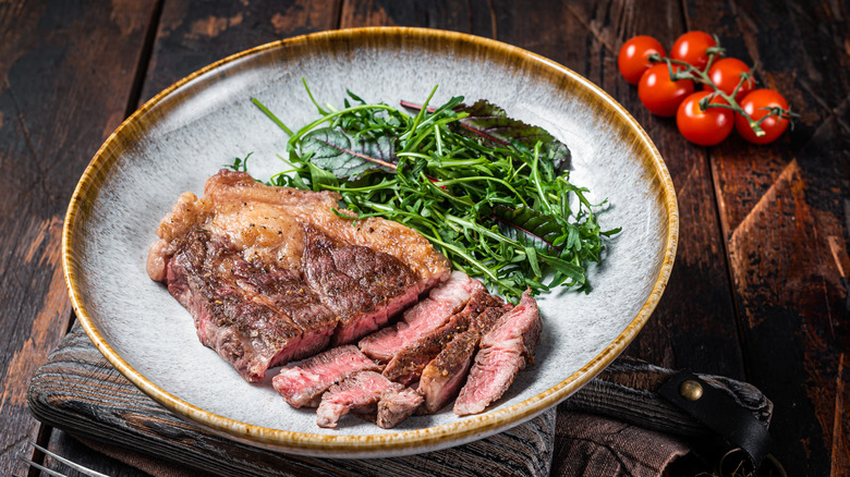 Chuck steak on plate with greens