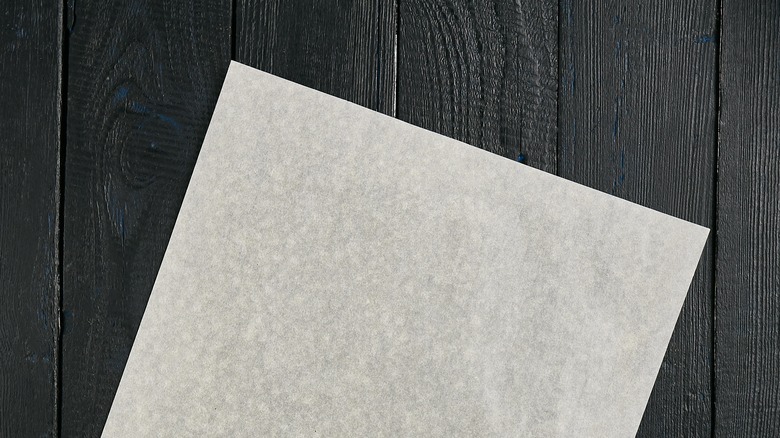 Square of white paper on black wood background