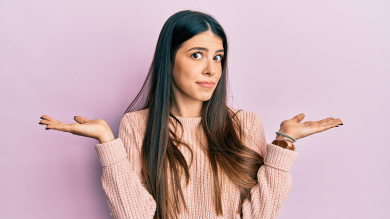 Woman with brown hair shrugging