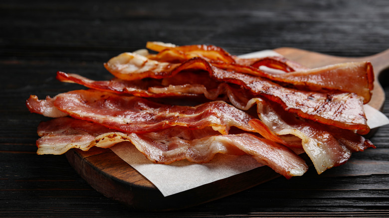 cooked bacon on paper sitting on wooden cutting board