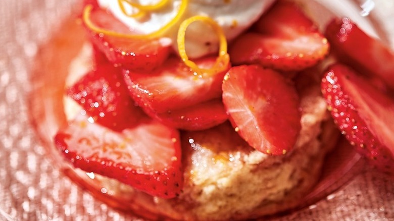 Biscuit with strawberries, cream, and orange zest.