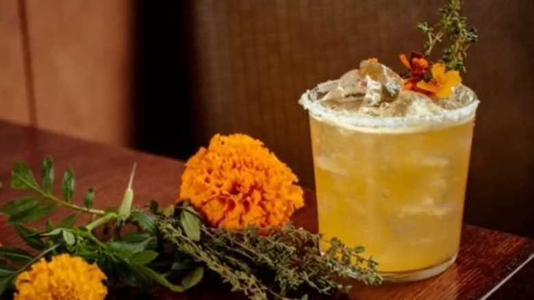 Margarita with salt rim and marigold flowers.