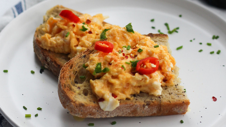 Toasts topped with scrambled eggs and chili peppers.