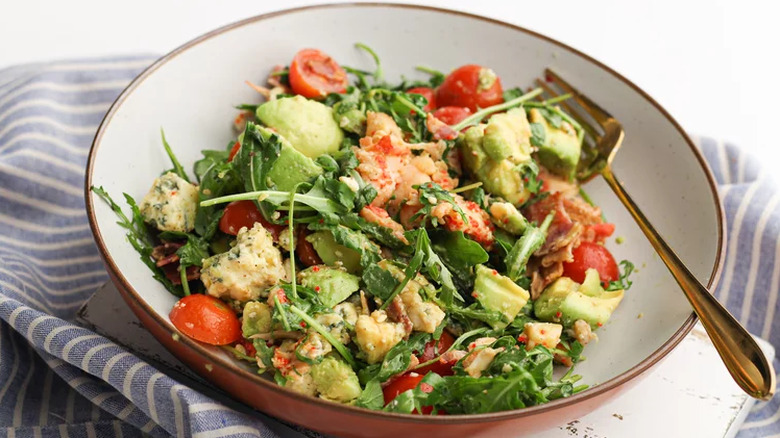 Bowl of salad with lobster and tomatoes.